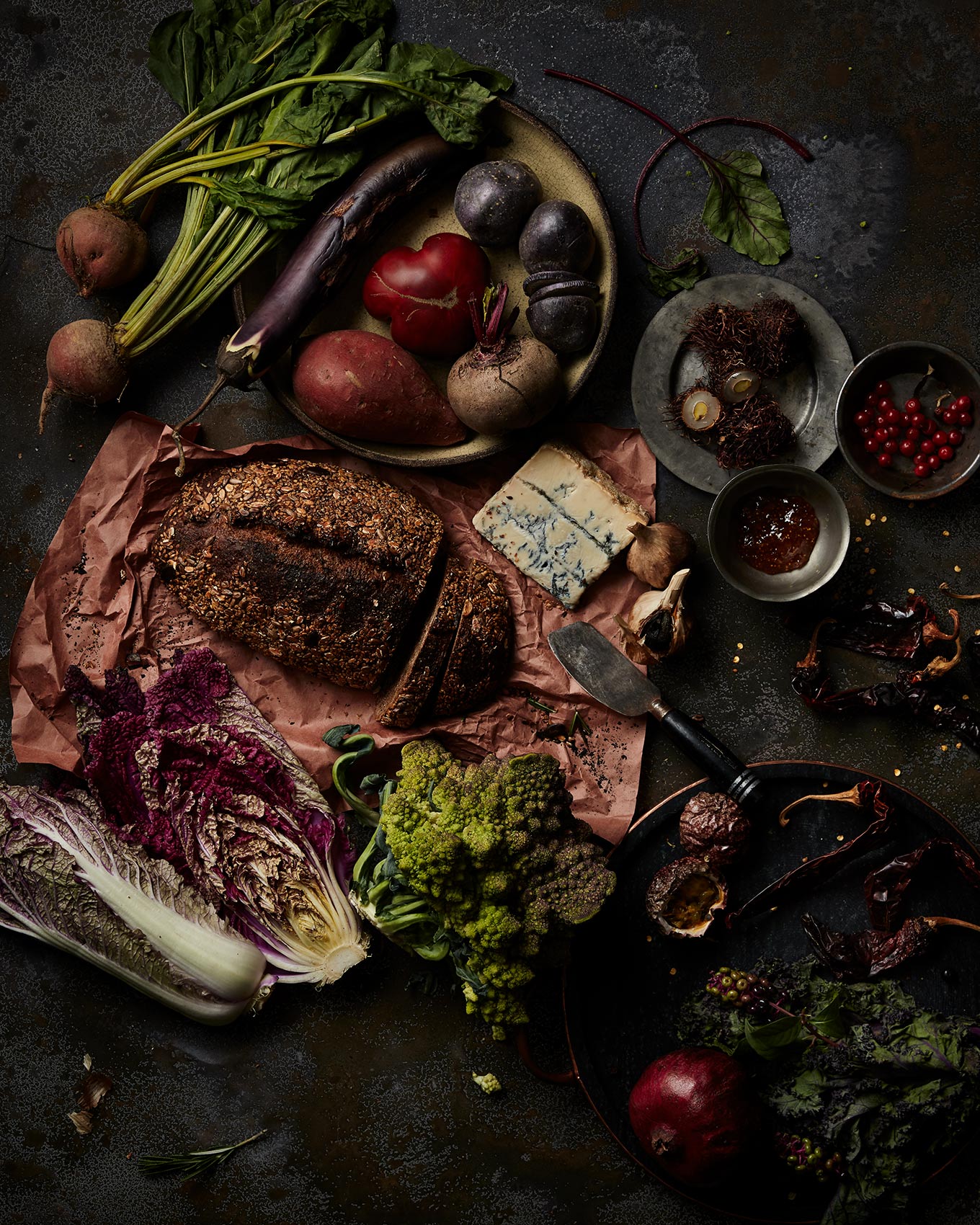 Rich dark earthy foods displayed on a rustic  neutral background.